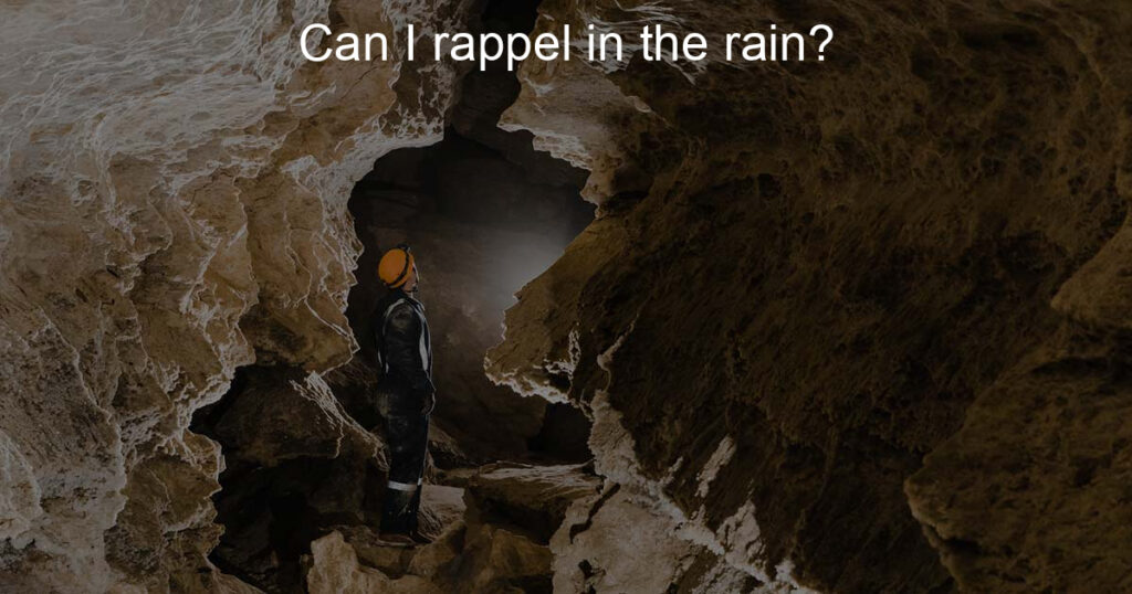 Man rapelling in the cave while raining